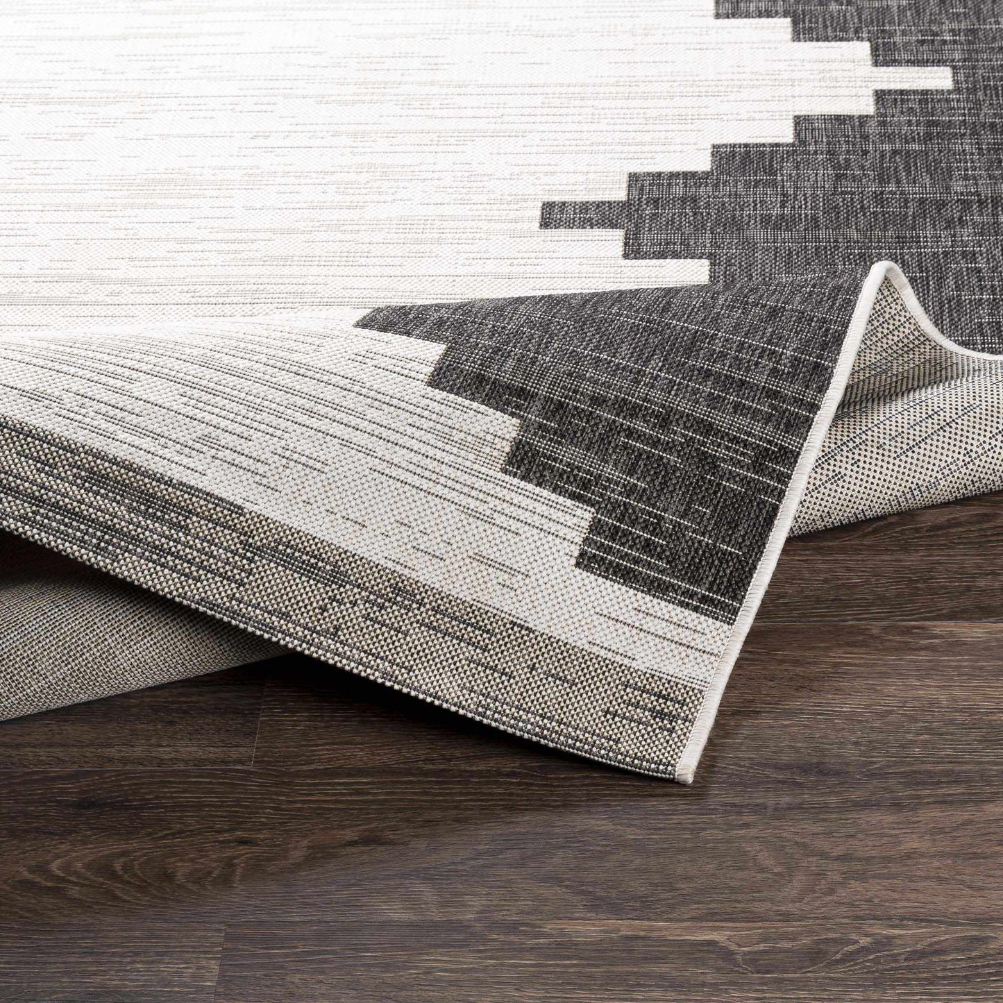 Gray and white geometric patterned rug on a wooden floor
