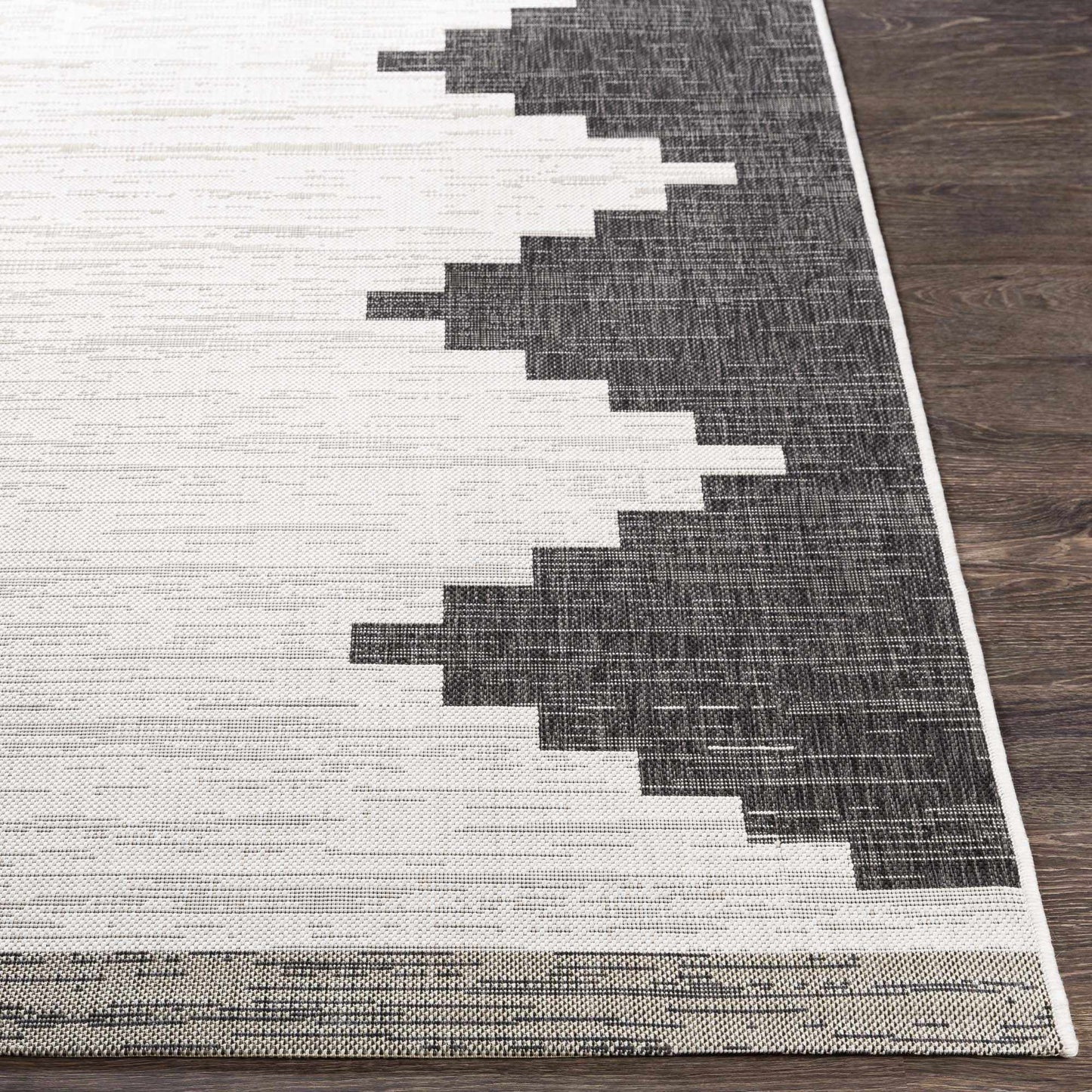 Gray and white geometric patterned rug on a wooden floor