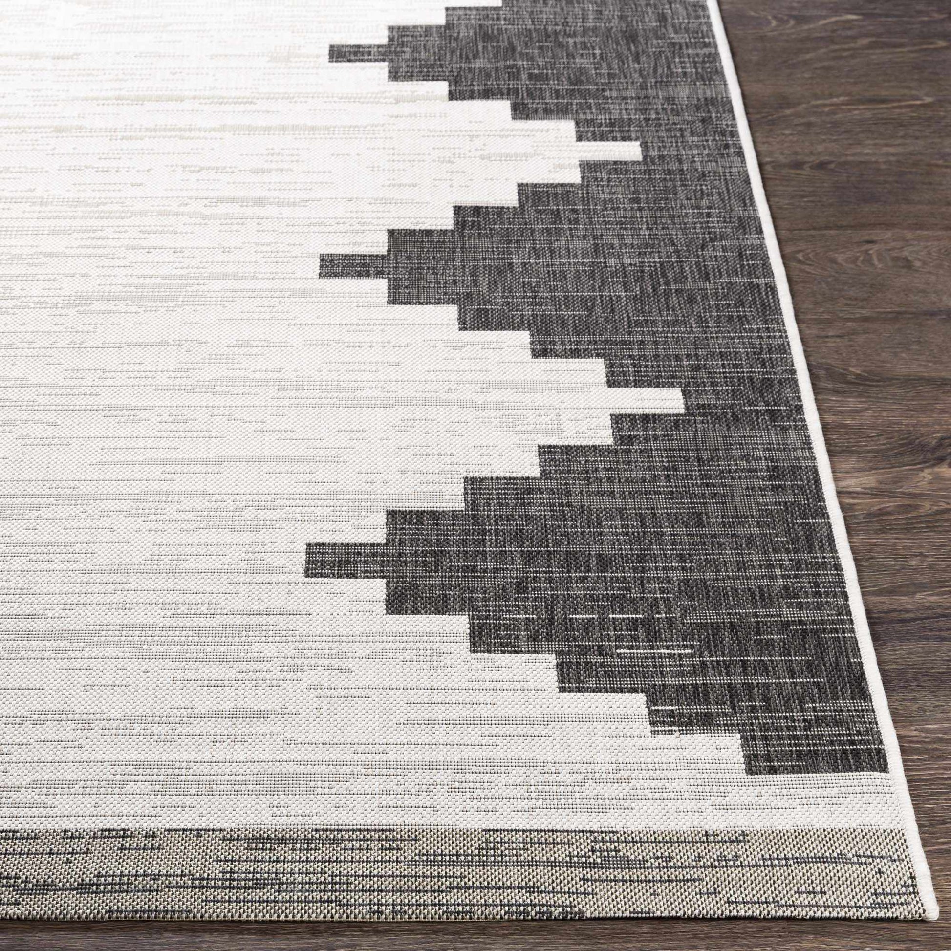 Gray and white geometric patterned rug on a wooden floor