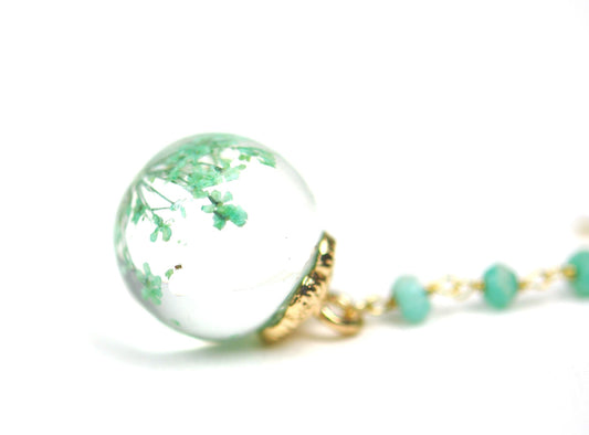 Close-up of petrified flower encased in glass globe with gold detail