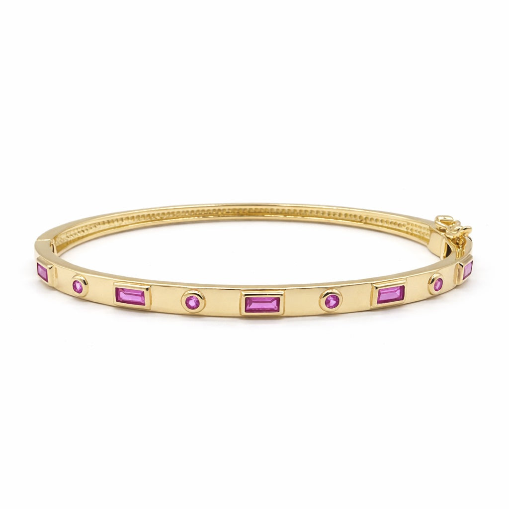 Gold bangle bracelet with bezel-set pink topaz stones