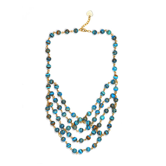 Flat lay of layered stripe turquoise beaded necklace with gold chain